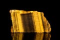 Raw golden tiger eye mineral stone in front of black background Royalty Free Stock Photo