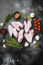 Raw goose wings, on black dark stone table background, top view flat lay, with copy space for text