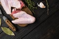 Raw goose wings, on black wooden table background, top view flat lay, with copy space for text