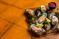 Raw green kiwi mussels in shells with herbs. Orange background. Top view. Copy space