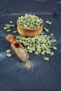 Raw green unroasted coffee in wooden bowl with ground beans in wood scoop Royalty Free Stock Photo