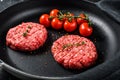 Raw Ground beef meat Burger steak cutlets in a pan. Black background. Top view Royalty Free Stock Photo