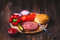 Raw Ground beef meat Burger steak cutlets with seasoning, cheese, tomatoes, salad and bun on vintage wooden boards Royalty Free Stock Photo