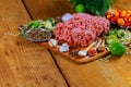 Raw Ground beef meat Burger steak cutlets with seasoning, tomatoes, Royalty Free Stock Photo