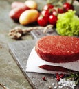 Raw Ground beef meat Burger steak cutlets with seasoning and veg Royalty Free Stock Photo