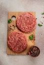 Raw Ground beef meat Burger steak cutlets on a wooden board, Food recipe background. Close up, vertical image. top view Royalty Free Stock Photo