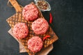 Raw ground meat beef burgers on a wooden board. Royalty Free Stock Photo