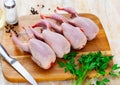 Raw gutted partridges on wooden table with seasonings and greens