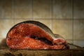raw gutted rainbow trout with spices without a head lies front cross-cut on a cutting board on a soft beige kitchen tile Royalty Free Stock Photo