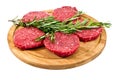 Raw hamburgers with cellophane and rosemary on wooden board Royalty Free Stock Photo