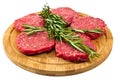 Raw hamburgers with cellophane and rosemary on wooden board Royalty Free Stock Photo