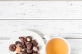 Raw handmade chocolate candies, cup of tea on white wooden table Royalty Free Stock Photo