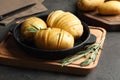 Raw Hasselback potatoes with rosemary in baking pan on grey table Royalty Free Stock Photo