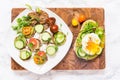 Raw healthy burger with avocado dressing, cucumbers, poached egg Royalty Free Stock Photo