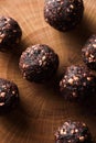 Raw healthy sugar free dessert. Bliss balls made of green buckwheat, nuts and dried fruits on wooden slab close up low key