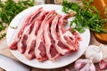 Raw hogget chops on plate with arugula, garlic and seasonings Royalty Free Stock Photo