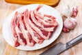 Raw hogget chops on plate with garlic and knife Royalty Free Stock Photo