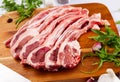 Raw hogget chops on wooden board with arugula and garlic Royalty Free Stock Photo