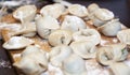 Raw homemade dumplings with minced meat on wooden board on table,  sprinkled with flour. Close up view of traditional Russian Royalty Free Stock Photo