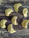 Raw homemade dumplings with potatoes on a wooden table close-up. Dough product. View from above Royalty Free Stock Photo