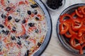 Raw homemade Pizza and Ingredients with red pepper and black olives on white wooden table Royalty Free Stock Photo