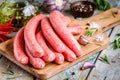 Raw homemade sausages on cutting board with rosemary and garlic Royalty Free Stock Photo