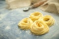 Raw homemade spaghetti nest with flour in a kitchen. Fresh Italian Cappellini pasta