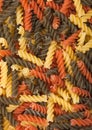 Raw homemade tricolore fusilli pasta as texture background