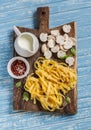 Raw ingredients for cooking pasta with mushroom cream sauce - pasta, mushrooms, cream, spices. Royalty Free Stock Photo
