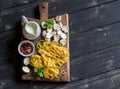 Raw ingredients for cooking pasta with mushroom cream sauce - pasta, mushrooms, cream, spices. On rustic wooden board Royalty Free Stock Photo