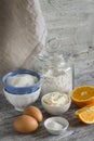 Raw ingredients - flour, eggs, butter, sugar, orange - to cook orange cake.