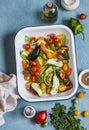 Raw ingredients for lunch - fresh chopped vegetables in the pan on a blue background, top view.