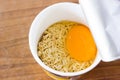 raw instant noodle in cup add egg Royalty Free Stock Photo