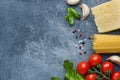 Raw Italian pasta spaghetti and cooking ingredients cherry tomatoes Cheese greens. Italian food dark stone background. Top view Royalty Free Stock Photo