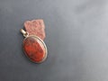 Raw Jasper and Jasper polished pendant against Black Background. Royalty Free Stock Photo