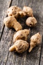 Raw jerusalem artichoke. Topinambur vegetable root on wooden table Royalty Free Stock Photo