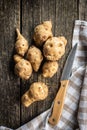 Raw jerusalem artichoke. Topinambur vegetable root on wooden table Royalty Free Stock Photo