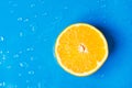 Raw juicy citrus fruit cut in half orange on wet blue background with water drops splashes. Summer beverages refreshments drinks Royalty Free Stock Photo