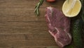 Raw juicy meat steaks ready for roasting on a wooden background Royalty Free Stock Photo