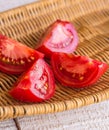 Raw juicy red tomato quarters in a wicker basket Royalty Free Stock Photo