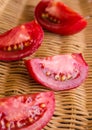 Raw juicy red tomato quarters in a wicker basket Royalty Free Stock Photo