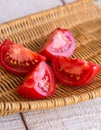 Raw juicy red tomato quarters in a wicker basket Royalty Free Stock Photo