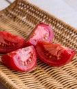 Raw juicy red tomato quarters in a wicker basket Royalty Free Stock Photo