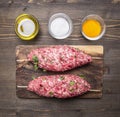 Raw kebab skewers on a chopping board with spices wooden rustic background top view close up
