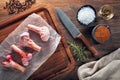 Raw lamb bones on white cooking paper and wooden cutting table