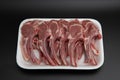 Raw lamb chops cutlets in a white styrofoam container isolated on black background with copy space for text Royalty Free Stock Photo