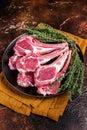 Raw lamb chops, fresh mutton meat cutlets on a ribs. Dark background. Top view