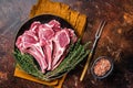 Raw lamb chops, fresh mutton meat cutlets on a ribs. Dark background. Top view