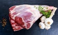 Raw lamb leg on blue stone background with herbs Royalty Free Stock Photo
