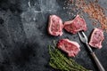 Raw lamb loin steaks, chops cutlets on kitchen table. Black background. Top view. Copy space Royalty Free Stock Photo